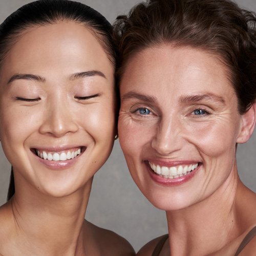 Headshot of two female models smiling together